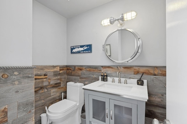 bathroom with vanity, tile walls, and toilet