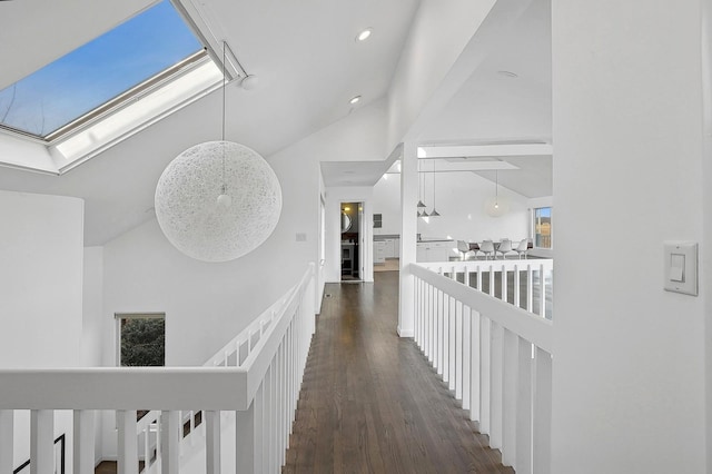 hall with dark wood-type flooring and lofted ceiling with skylight