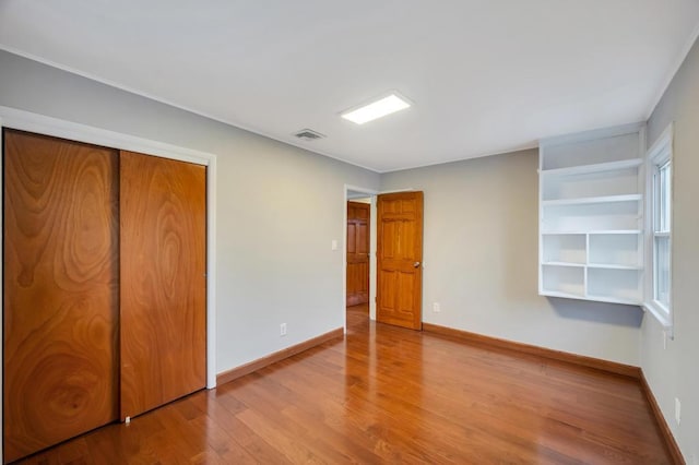 unfurnished bedroom with hardwood / wood-style flooring and a closet