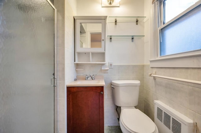 bathroom featuring tile walls, radiator heating unit, vanity, toilet, and walk in shower