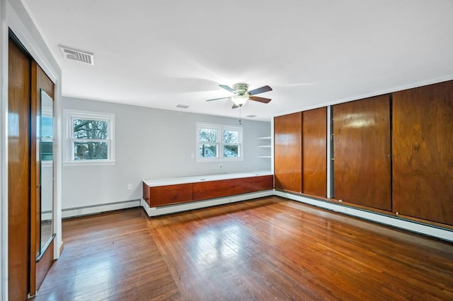 unfurnished bedroom featuring hardwood / wood-style flooring, a closet, ceiling fan, and baseboard heating