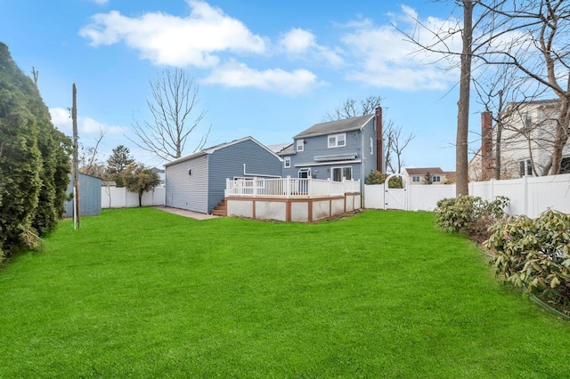 rear view of property with a pool side deck and a yard