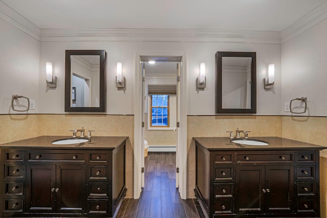 bathroom with vanity, ornamental molding, hardwood / wood-style floors, and baseboard heating