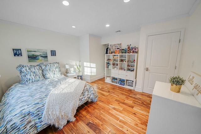 bedroom with crown molding and hardwood / wood-style floors