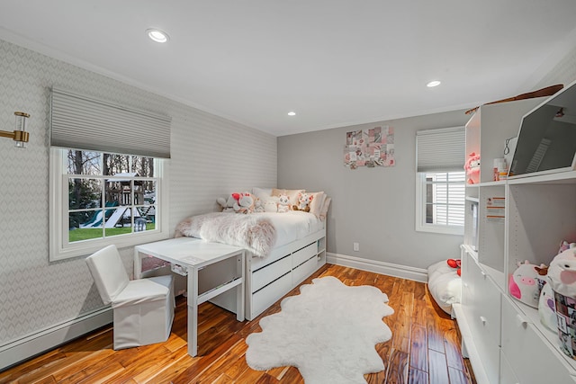 bedroom featuring wood-type flooring, crown molding, and baseboard heating