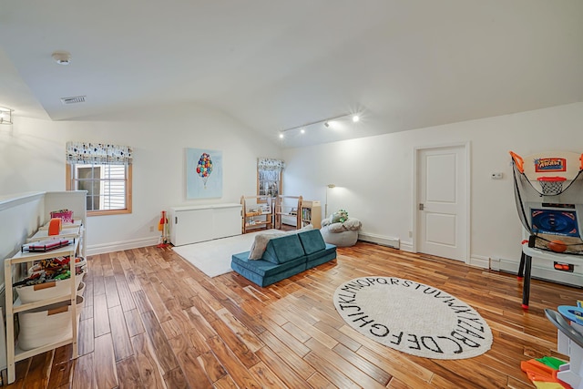 rec room with lofted ceiling, a baseboard heating unit, track lighting, and hardwood / wood-style floors