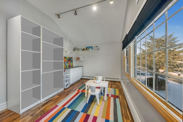 game room with lofted ceiling, a baseboard heating unit, and hardwood / wood-style floors