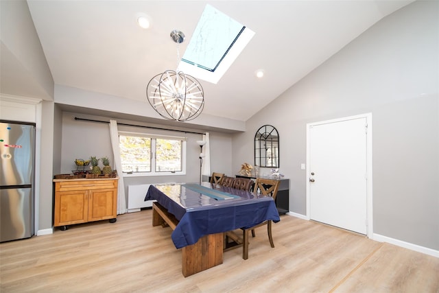 dining room featuring a notable chandelier, a skylight, high vaulted ceiling, and light wood-type flooring