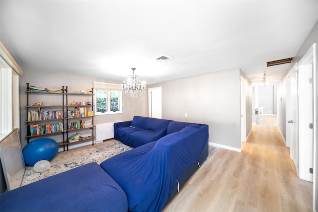 living room with an inviting chandelier and light hardwood / wood-style flooring