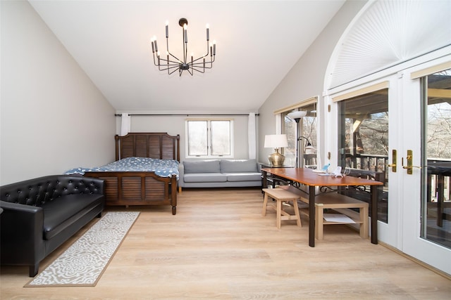 bedroom with lofted ceiling, light hardwood / wood-style flooring, access to outside, a notable chandelier, and french doors