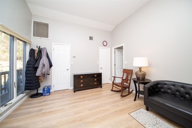 sitting room featuring high vaulted ceiling and light hardwood / wood-style floors