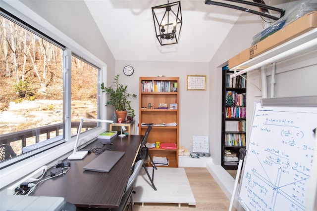 office area with vaulted ceiling, a notable chandelier, and light hardwood / wood-style floors