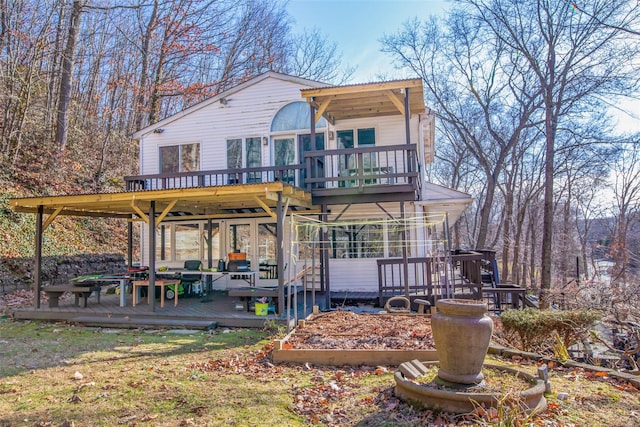 back of property featuring a sunroom and a deck