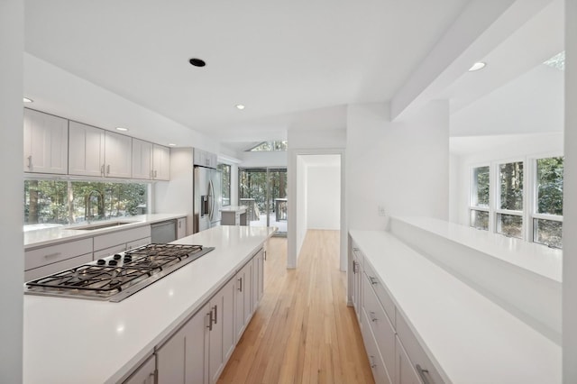 kitchen featuring sink, stainless steel appliances, white cabinetry, and light wood-type flooring