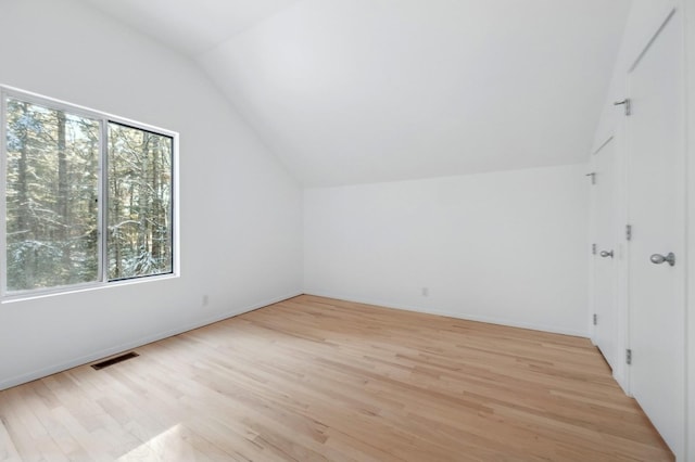 bonus room with light hardwood / wood-style flooring and lofted ceiling