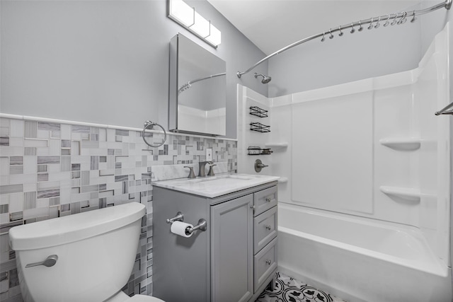 full bathroom featuring vanity, bathing tub / shower combination, tile walls, and toilet