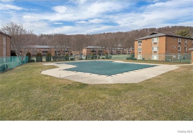 view of pool with a patio and a lawn