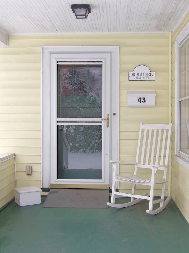 view of exterior entry featuring covered porch