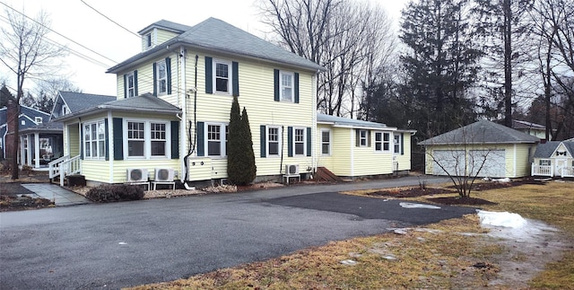 view of front of property with an outbuilding, cooling unit, a garage, and entry steps