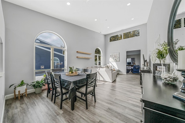 dining space featuring a high ceiling and light wood-type flooring