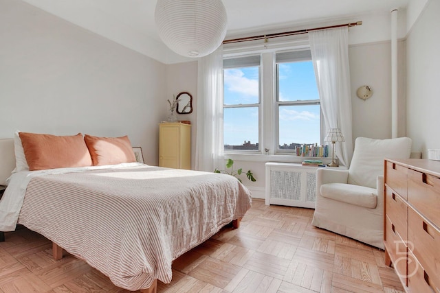 bedroom featuring light parquet floors and radiator