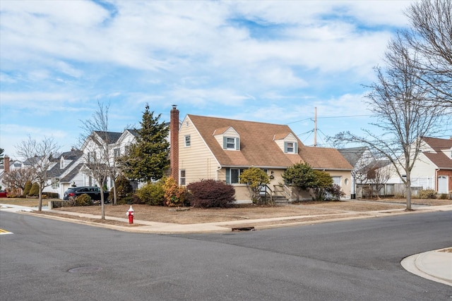 cape cod house with a residential view and a chimney