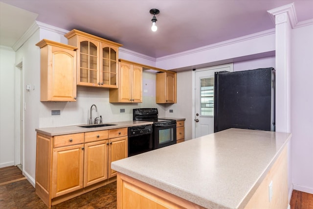 kitchen featuring a sink, light countertops, ornamental molding, black appliances, and glass insert cabinets