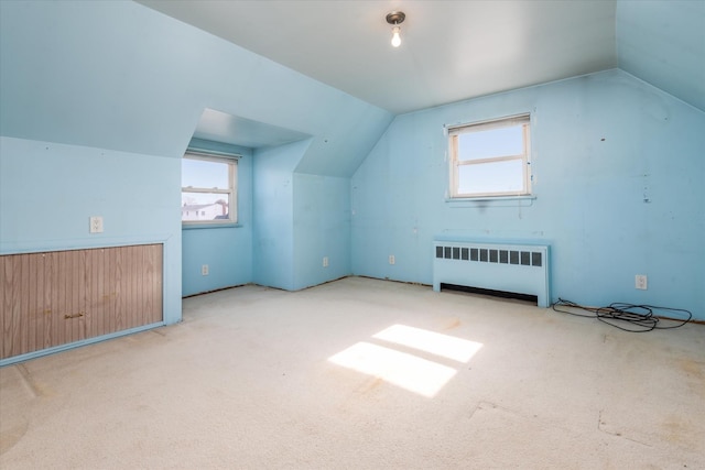 bonus room with a wealth of natural light, lofted ceiling, and radiator heating unit