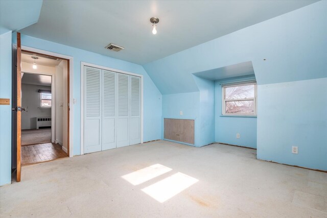 bonus room with light carpet, plenty of natural light, visible vents, and radiator