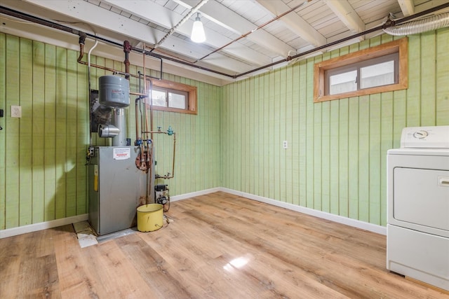 basement featuring baseboards, washer / clothes dryer, and wood finished floors