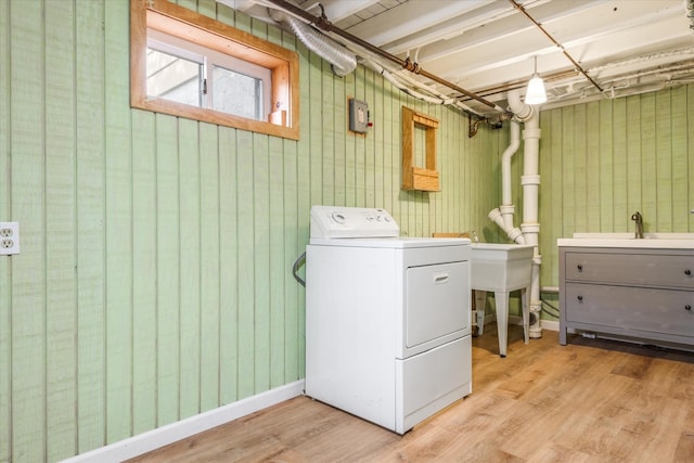 clothes washing area featuring baseboards, washer / clothes dryer, a sink, and wood finished floors