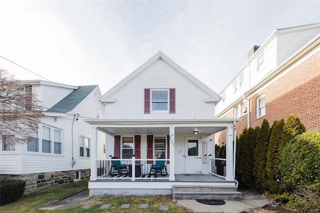 rear view of property featuring covered porch