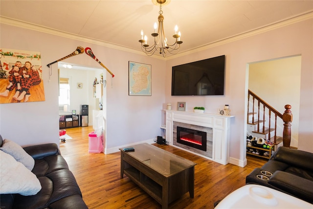 living room with a notable chandelier, hardwood / wood-style flooring, and ornamental molding