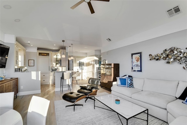 living room featuring ceiling fan and light hardwood / wood-style floors