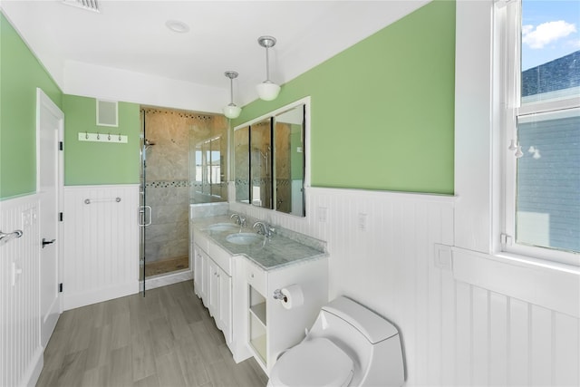 bathroom with hardwood / wood-style flooring, vanity, toilet, and an enclosed shower