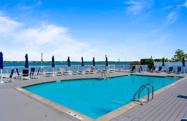 view of pool featuring a water view and a patio area