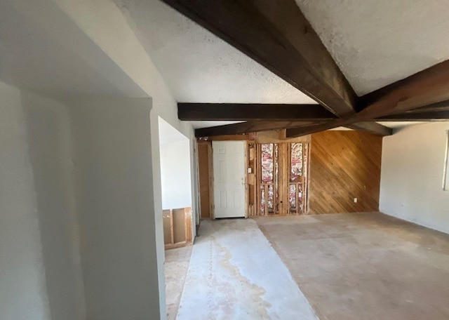 bonus room with beamed ceiling and wood walls