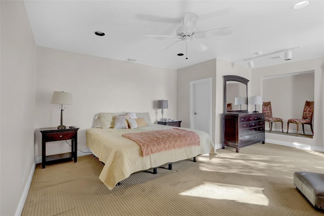 carpeted bedroom with rail lighting and ceiling fan