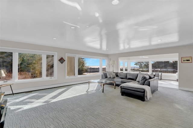 carpeted living room featuring a baseboard heating unit