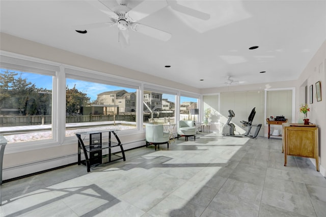 sunroom / solarium with a baseboard heating unit and ceiling fan