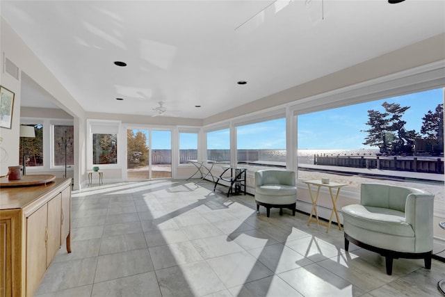 sunroom / solarium featuring ceiling fan