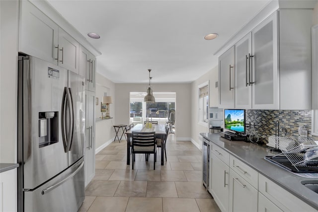 kitchen with stainless steel refrigerator with ice dispenser, wine cooler, white cabinetry, pendant lighting, and backsplash