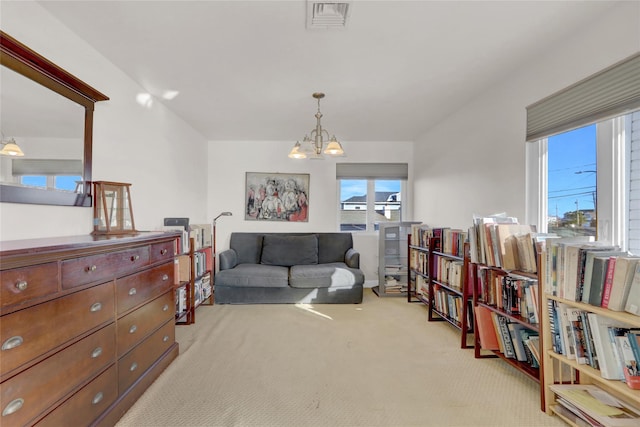 living area featuring light colored carpet and a chandelier