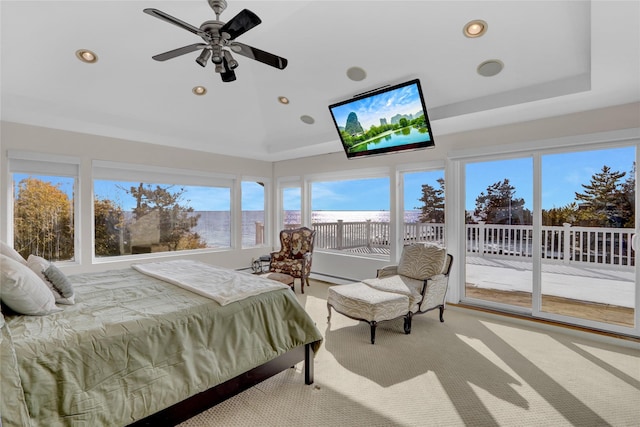 bedroom with light carpet, access to exterior, and a tray ceiling