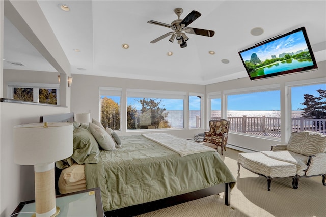 bedroom with access to exterior, a tray ceiling, and baseboard heating