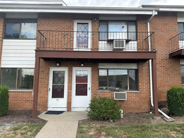 exterior space featuring a balcony and an AC wall unit