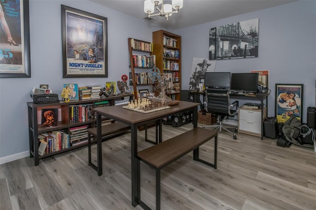 home office featuring a chandelier and light hardwood / wood-style flooring