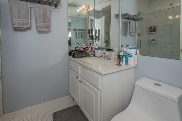 bathroom featuring vanity, toilet, tile patterned flooring, and a tile shower