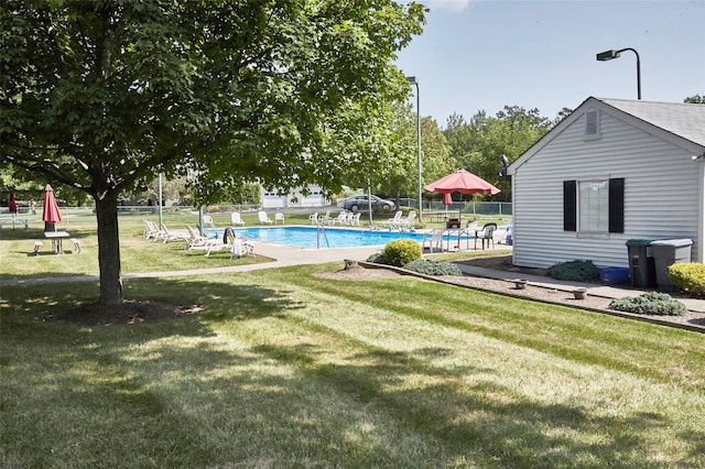 view of swimming pool featuring a yard