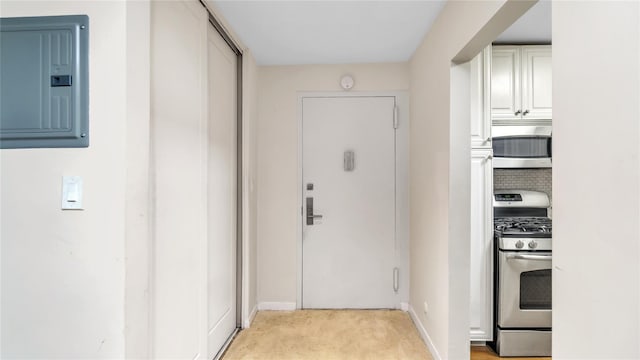 hallway featuring light carpet and electric panel